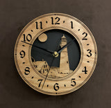 Round oak clock with a lighthouse, moon and lightkeeper's house lasered in the face against a black background - 8" size