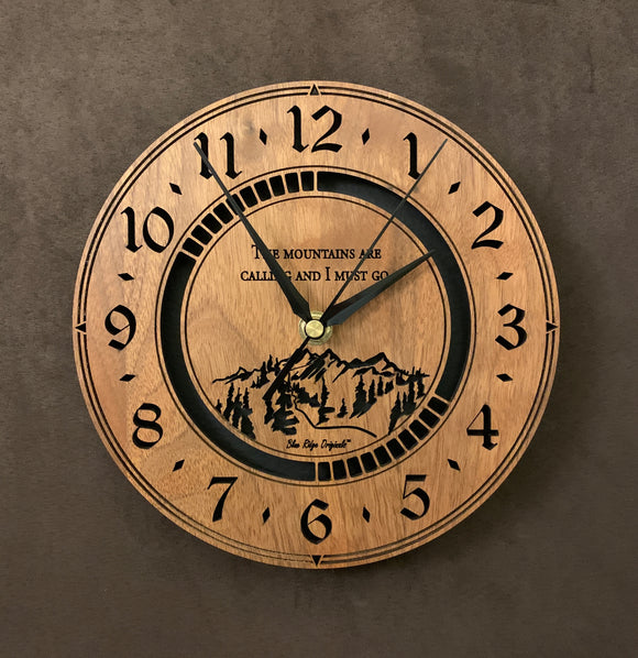 Round walnut clock with a mountain and the words, 