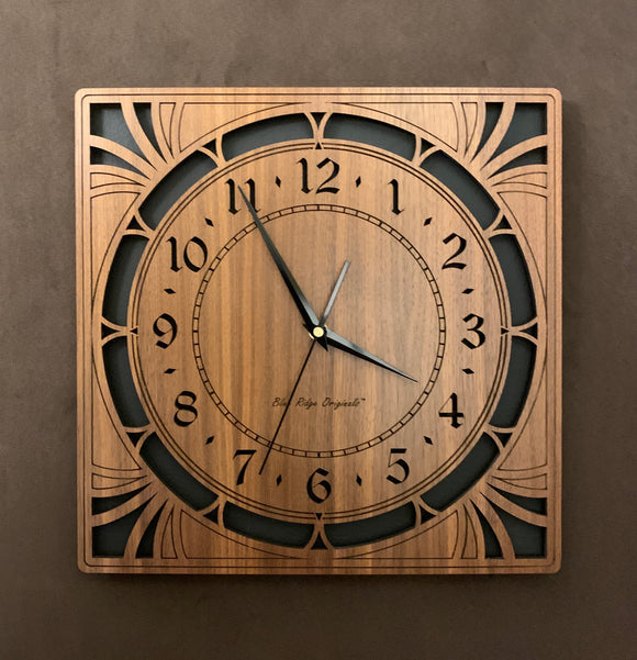 A square walnut clock with cutouts forming a patterned circle around the face and numbers of the clock and cutout flourishes in the corners. Somewhat in an Art Deco style. Larger Sizes
