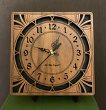 A square walnut clock with cutouts forming a patterned circle around the face and numbers of the clock and cutout flourishes in the corners. Somewhat in an Art Deco style. 8" Size on easel