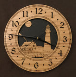 Round oak clock with a lighthouse, moon and lightkeeper's house lasered in the face against a black background - larger sizes