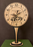 Round Oak clock with a mountain and the words, "Not all who wander are lost" lasered in the face - 6.5" on tall stand