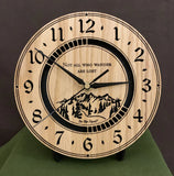 Round Oak clock with a mountain and the words, "Not all who wander are lost" lasered in the face - 8" on easel