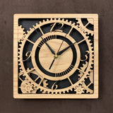 Square oak clock with black background. The front shows a large single gear surrounded by smaller gears and partial gears, and the numbers 12, 3 , 6, 9. One layer down are two smaller gears. 8" size