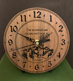 Round walnut clock with a mountain and the words, "The mountains are calling and I must go" lasered in the face - 6.5" on easel