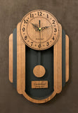 Oblong walnut and black pendulum clock consisting of a round face and, under it to either side, 3 alternating walnut and black rounded segments which decrease in size from front to back. The clock has a rounded bottom and a black background beneath the face. Front view, smaller sizes