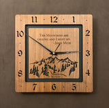 A square walnut clock with the numbers on the outer square section, while on the inner square section a mountain and the words, "The Mountains are calling and I must go. -John Muir" are lasered in the wood. The concentric wood squares have a gap between them and are against a black background. Larger Sizes