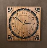A square walnut clock with cutouts forming a patterned circle around the face and numbers of the clock and cutout flourishes in the corners. Somewhat in an Art Deco style. 10" Size