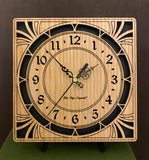 A square oak clock with cutouts forming a patterned circle around the face and numbers of the clock and cutout flourishes in the corners. Somewhat in an Art Deco style. 8" size on easel