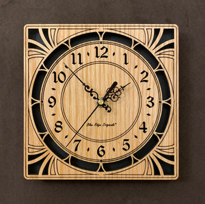 A square oak clock with cutouts forming a patterned circle around the face and numbers of the clock and cutout flourishes in the corners. Somewhat in an Art Deco style. Larger Sizes