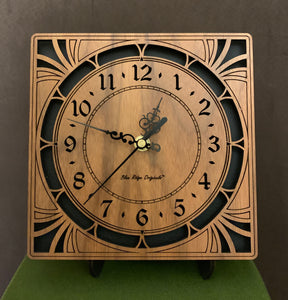A square walnut clock with cutouts forming a patterned circle around the face and numbers of the clock and cutout flourishes in the corners. Somewhat in an Art Deco style. Larger Sizes