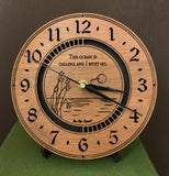 Round walnut clock with an ocean scene of sun, birds and ripples in the water along with the words, "The ocean is calling and I must go" lasered in the face - 8" on easel