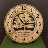 Oak clock with lasered tree and small bird, with the words, "Family gives us roots and wings" -  on easel